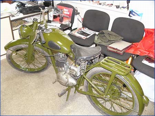Старинный мотоцикл настолько дорог хозяину, что стоит прямо в офисе перед рабочим столом.